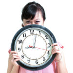 Woman holding clock to expose meal timing myths